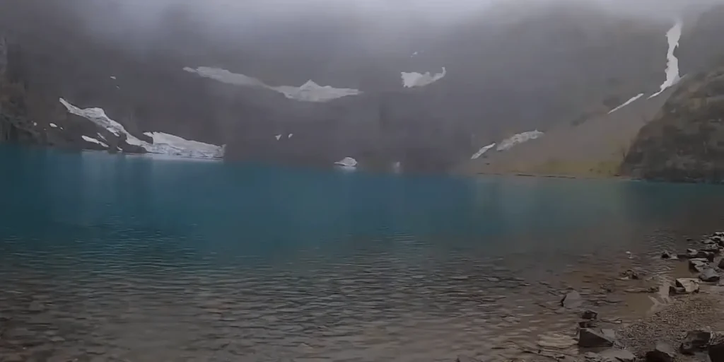 View of Iceberg Lake Trail with green mountains & lake at Glacier National Park