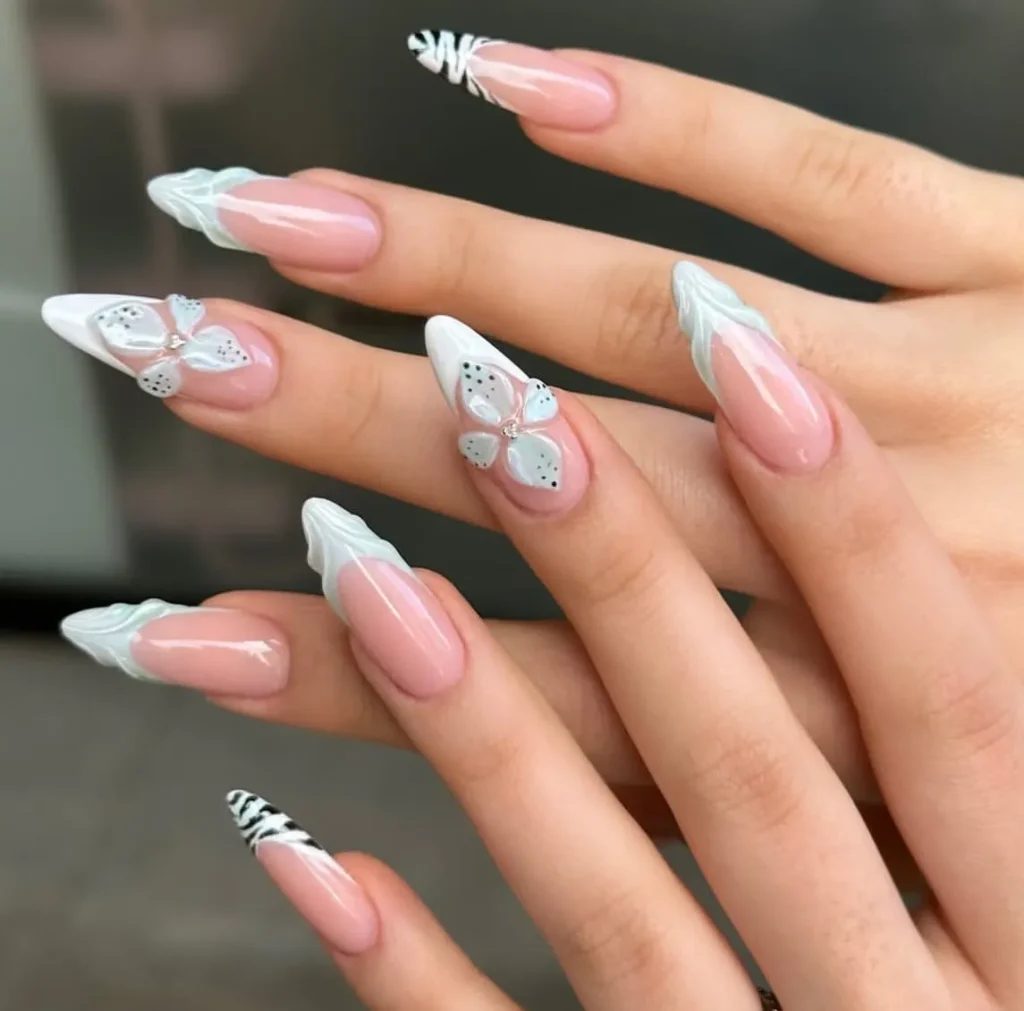 Long stiletto nails with cascading 3D pink cherry blossoms with brown branches on nude pink base